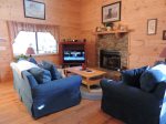 The living area is open with a comfortable sofa, love seat ,TV and gas fireplace.